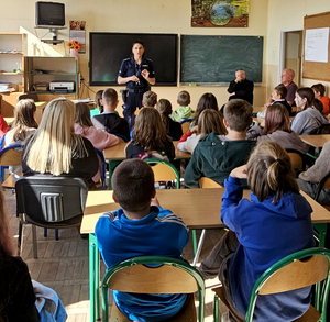 Policjantka z grupą uczniów w sali