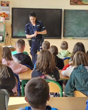 Policjantka z grupą uczniów w sali