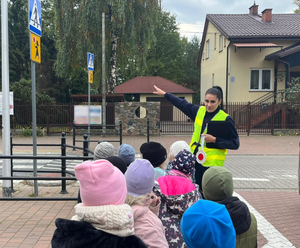 Policjantka z grup a dzieci na przejściu dla pieszych