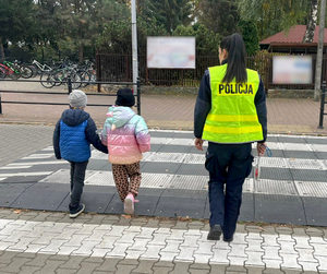 Policjantka z dwójką dzieci na przejściu dla pieszych