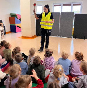 Policjantka z grupą dzieci podczas zajęć w sali