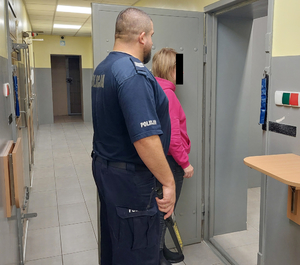 Policjant z zatrzymaną kobietą przed celą