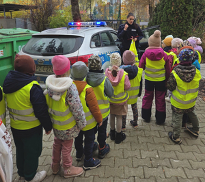 Policjantka z grupą dzieci przy radiowozie