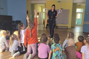 Policjantka z grupą dzieci w sali przedszkola