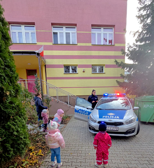 Policjantka z grupa dzieci przy radiowozie