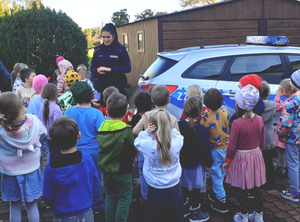 Policjantka z grupą dzieci przy radiowozie