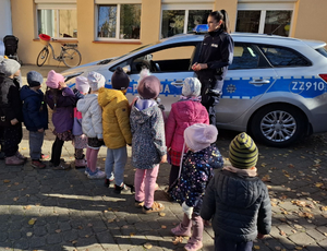 policjantka z grupą dzieci przy radiowozie