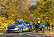 radiowóz i motocykl w jesiennych warunkach na drodze