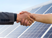 uścisk rąk na tle paneli fotowoltaicznych