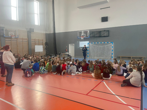 Policyjny profilaktyk z grupą uczniów w sali