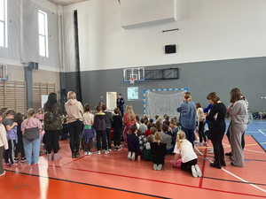 Policyjny profilaktyk z grupą uczniów w sali