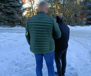 Policjant kryminalny z zatrzymanym mężczyzną