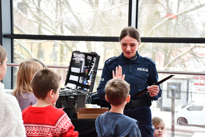 Policjantka rozdaje odblaski dzieciom