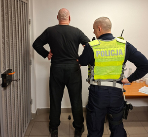 Policjant z zatrzymanym kierowcą przed celą