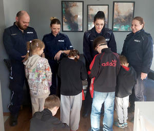 Policjanci przekazują dzieciom upominki