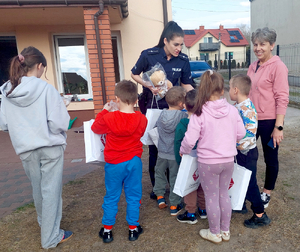 Policjantka przekazuje dzieciom upominki