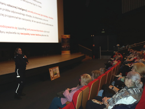 uczestnicy spotkania i policjantka w sali kinowej