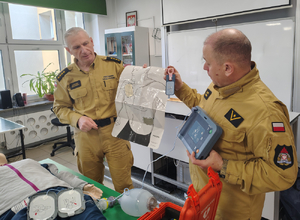 Uczestnicy turnieju i dwóch strażaków w sali