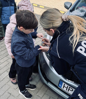 policjantka z dziećmi przy radiowozie