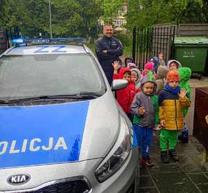 radiowóz i policjant z dziećmi