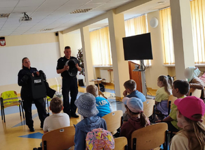 Policjanci i dzieci podczas spotkania w komendzie